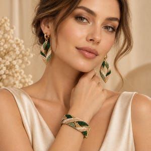 Op de afbeelding: Een sieradenset bestaande uit twee marquisevormige oorbellen en een brede armband. Elk sieraad is gemaakt van kleine kraaltjes in bosgroen, saliegroen, crème en metallic goud, gerangschikt in een geweven, gedraaid patroon.