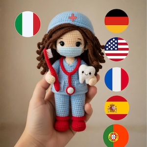 Puede incluir: Muñeca de ganchillo que representa a un trabajador de la salud, con uniforme azul, gorro y mascarilla. La muñeca tiene cabello castaño y sostiene un cepillo de dientes rojo y un diente blanco. Un estetoscopio rojo está alrededor del cuello.