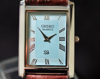 Reloj clásico Seiko Slim Tank vintage con esfera azul y caja plateada.