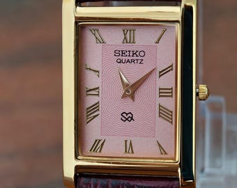 Reloj Seiko Slim Tank vintage con esfera rosa y caja dorada, pieza única.