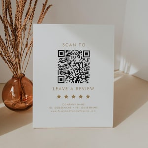 Könnte beinhalten: Ein weißes rechteckiges Schild mit einem schwarzen QR-Code über dem goldenen Text SCAN TO LEAVE A REVIEW. Unter dem Text befinden sich fünf goldene Sterne, gefolgt von dem Platzhaltertext COMPANY NAME, IG: @USERNAME, FB: @USERNAME und www.FreshAndYummyPaperie.com.
