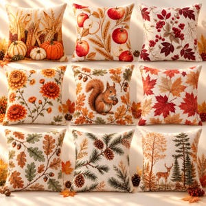 Könnte beinhalten: Ein Set aus neun quadratischen Kissen mit herbstlichen Motiven, darunter Kürbisse, Mais, Äpfel, Weizen, rote Beeren, orangefarbene Chrysanthemen, ein Eichhörnchen mit Eicheln, Ahornblätter, Eichenblätter, Tannenzapfen und ein Hirsch im Wald.