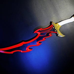 Könnte beinhalten: Ein dekorativer Dolch mit roter und schwarzer Klinge und weißem Griff. Die Klinge hat ein einzigartiges, flammenartiges Design. Der Knauf und die Parierstange sind goldfarben. Der Dolch wird vor einem dunklen Hintergrund präsentiert.