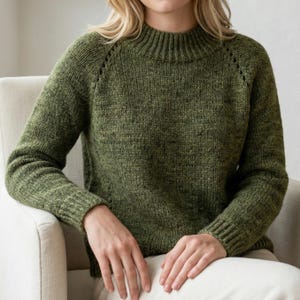 Peut inclure: Un pull vert tricoté avec un col montant côtelé et des manches longues. Le pull a un aspect texturé et est fait d'une matière douce et confortable. Les manches ont un détail de couture décoratif près de l'épaule.