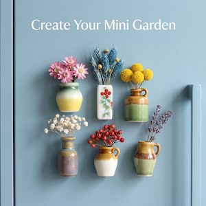 Può includere: Sei piccoli magneti a forma di vaso in ceramica disposti su una superficie azzurra, ognuno contenente fiori secchi. Il testo 'Create Your Mini Garden' è visualizzato sopra. I vasi presentano forme, colori e composizioni floreali varie, inclusi fiori rosa, gialli e rossi.