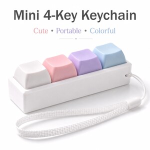 May include: A white Mini 4-Key Keychain with four pastel-colored keycaps: white, pink, purple, and blue. The keychain has a white wrist strap. The text on the image says "Cute, Portable, Colorful."