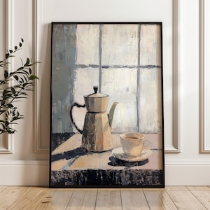 May include: A framed art print depicting a still life with a coffee pot and a cup of coffee. The painting, in muted tones of beige, grey, and white, shows visible brushstrokes. The artwork is set against a window backdrop and is presented in a black frame.