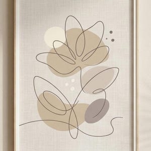 Puede incluir: Lámina de arte floral abstracto en un marco de madera. La obra presenta un dibujo de línea continua de una flor con formas orgánicas beige y marrón sobre un fondo neutro. El diseño general es minimalista y moderno.