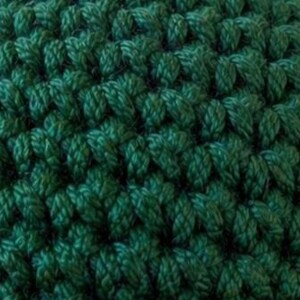 May include: A dark green crocheted fabric featuring a dense, uniform stitch pattern. The texture is created by interlocking loops of yarn, forming a consistent, repeating grid of V-shaped stitches across the entire surface of the material.