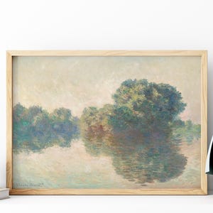 Può includere: Dipinto di paesaggio incorniciato in una cornice di legno chiaro. L'opera raffigura un sereno paesaggio acquatico con alberi riflessi nell'acqua. La tavolozza dei colori è tenue, con verdi, blu e marroni tenui.