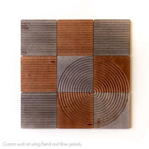 May include: A wall art piece made of nine square panels with a wood grain texture. The panels are arranged in a grid pattern, with the center panel featuring a circular design. The panels are in shades of brown and gray.