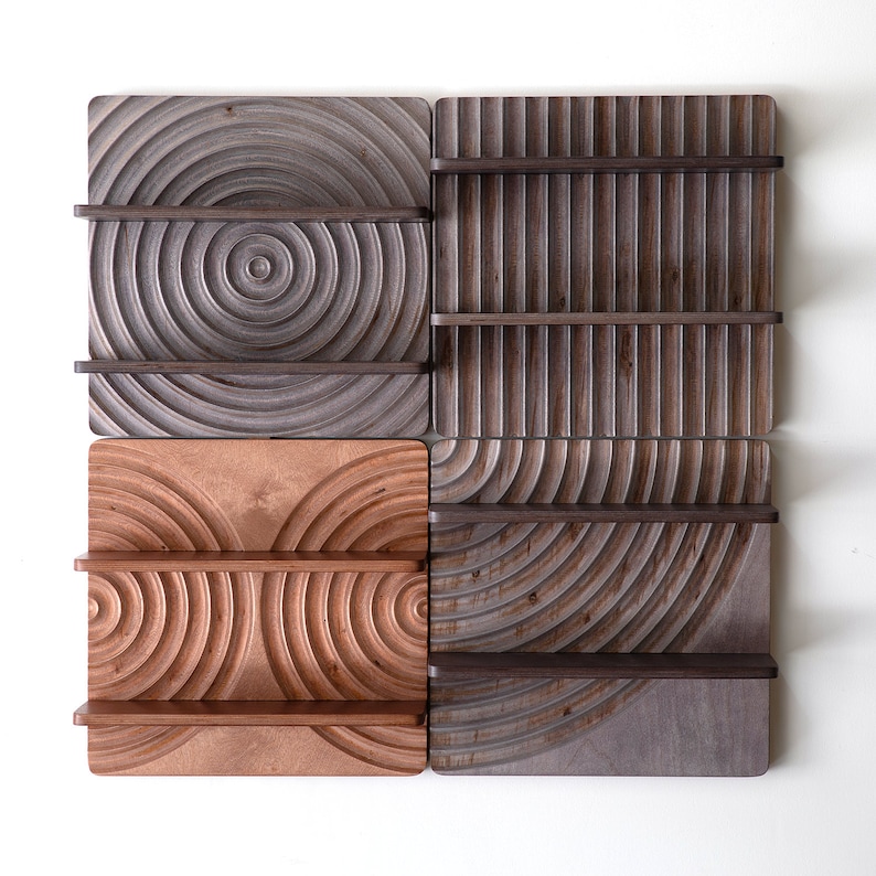 May include: Four square wooden wall shelves with different geometric patterns. The shelves are made of light and dark wood and have a natural finish.