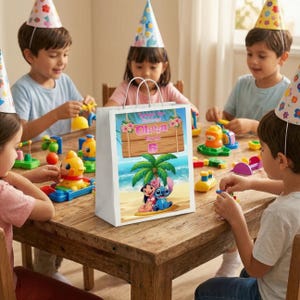 May include: A white gift bag with a tropical beach scene featuring the characters Lilo and Stitch. The bag has a wooden sign with the name "Oliva" and the number "6". Children wearing party hats are seated around a wooden table.