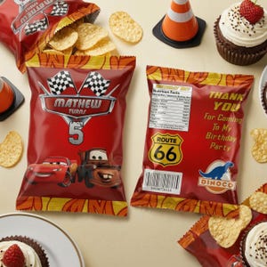 May include: Two red snack bags featuring cartoon race cars and the text Mathew Turns 5, Route 66, and Thank You For Coming To My Birthday Party. The bags are surrounded by loose potato chips, a small orange traffic cone, and chocolate cupcakes.