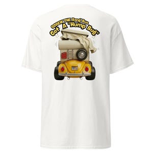 Puede incluir: Camiseta blanca con una ilustración de dibujos animados de un Volkswagen Beetle amarillo convertido en una autocaravana. El diseño incluye el texto "Screw the Bang Bus, Get A Hump Bug" en amarillo. La autocaravana tiene un techo beige y una rueda de repuesto.