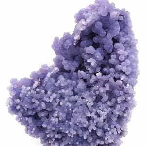 Puede incluir: Un racimo de ágata uva con numerosos cristales esféricos pequeños y translúcidos de color púrpura. La formación mineral tiene una textura botrioidal con diversos tonos de violeta y lavanda, creando una estructura superficial densa, orgánica y rugosa.
