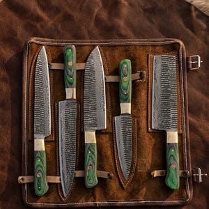May include: A set of five knives with textured blades and green wooden handles, displayed in a brown leather knife roll. The blades have a unique pattern, and the handles are accented with brass. The roll is secured with leather straps.
