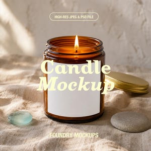 May include: A lit candle in an amber glass jar with a blank white rectangular label. The text "HIGH-RES JPEG & PSD FILE", "Candle Mockup", and "FOUNDRY MOCKUPS" is visible. A gold metal lid sits nearby on a textured fabric surface.