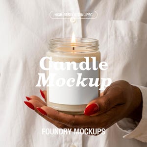May include: A lit candle in a clear glass jar with a white label, held in a person's hand. The text "Candle Mockup" is displayed on the candle, with "HIGH-RESOLUTION JPEG" and "FOUNDRY MOCKUPS" also visible.