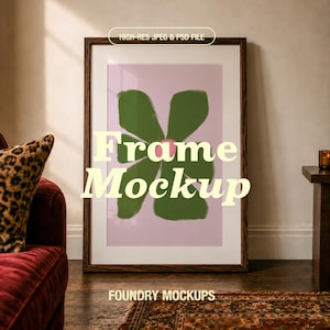May include: A dark wood rectangular picture frame containing a print of a green flower with a pink center on a light pink background. The text HIGH-RES JPEG & PSD FILE, Frame Mockup, and FOUNDRY MOCKUPS are printed over the image.