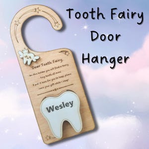 May include: Wooden tooth fairy door hanger with a star-shaped top and a tooth-shaped cutout. The text on the hanger reads "Tooth Fairy Door Hanger" and "Dear Tooth Fairy". The name "Wesley" is printed on the tooth cutout.