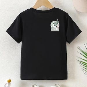 Peut inclure: T-shirt noir &agrave; manches courtes avec les armoiries mexicaines sur le haut de la poitrine gauche. L'embl&egrave;me repr&eacute;sente un aigle avec un serpent dans le bec, entour&eacute; d'une bordure verte et rouge, et le mot "MEXICO".