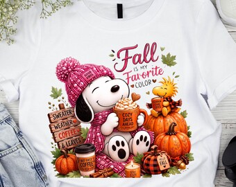 May include: A white t-shirt featuring a graphic of a cartoon dog wearing a pink knit hat and scarf, holding a mug labeled 'COZY DAYS AHEAD'. The design includes pumpkins, a sign reading 'SWEATER WEATHER COFFEE & LEAVES', and the text 'Fall IS MY FAVORITE COLOR'.
