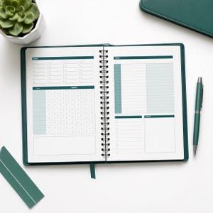 May include: An open teal-colored planner with a spiral binding, featuring daily, weekly, and monthly sections. A teal pen and a small succulent plant are also visible. The planner is on a white surface.