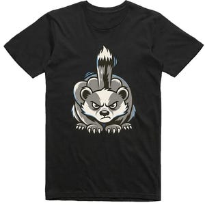 May include: Black t-shirt featuring a cartoon badger with an angry expression, giving the middle finger. The badger is gray, white, and black with blue accents. The design is centered on the shirt.