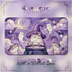 May include: A rectangular playmat featuring a purple watercolor illustration of a frog wearing a witch hat, stirring a cauldron. The design includes ghost cats, bats, a crescent moon, and labeled zones for Magic The Gathering gameplay.