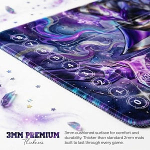 May include: A gaming mat with a cosmic design in shades of purple, blue, and white. The mat features a circular number system from 0 to 8. The text "3MM PREMIUM Thickness" is visible, along with the description "3mm cushioned surface for comfort and durability."