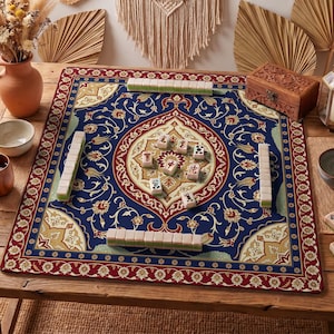 May include: A blue Mahjong game mat with a floral design and red border. The mat is set on a wooden table and features several stacks of tiles. A wooden box and vase are also visible.