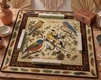 Könnte beinhalten: Ein dekoratives Mahjong-Spielset mit einem Design zum Thema Natur. Das Spielbrett zeigt bunte Vögel, Blumen und Blätter. Das Set enthält Spielsteine und wird auf einem Holztisch mit einer Holzkiste und dekorativen Elementen präsentiert.