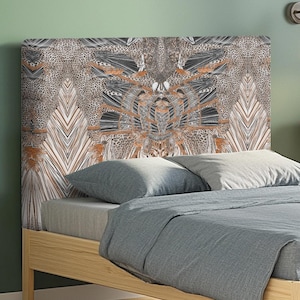 Peut inclure: Une tête de lit à motifs avec un design beige, marron et noir. La tête de lit est au centre d'un lit avec une literie grise et un cadre en bois clair. Le motif a un style géométrique et animal.