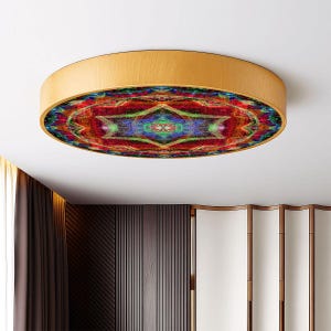 Puede incluir: Una lámpara de techo redonda con marco de madera. La lámpara presenta un diseño abstracto y colorido en rojo, verde, azul y amarillo. Está montada en un techo blanco.