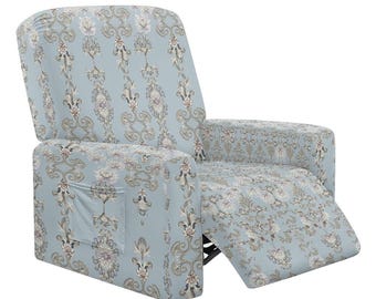 Puede incluir: Una funda de sillón reclinable azul claro con un estampado floral en blanco, gris y morado. La funda tiene un bolsillo lateral y está diseñada para adaptarse a un sillón reclinable. El diseño floral es de estilo damasco clásico.