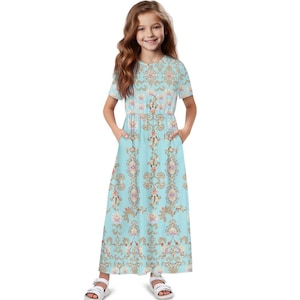 Può includere: Abito azzurro a maniche corte con motivo floreale. L'abito presenta una vita aderente e una gonna fluida. Il design floreale include elementi rosa, oro e crema. L'abito ha tasche ed è adatto per l'abbigliamento casual.