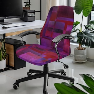 May include: A black office chair with a purple and red geometric patterned seat and back. The chair has adjustable arms and a five-star base with wheels.