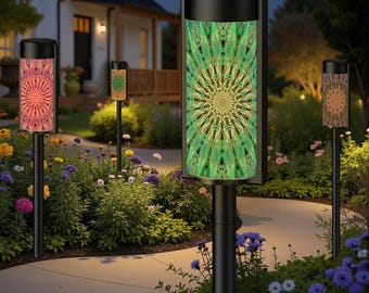 May include: Outdoor pathway lights with black poles and cylindrical shades. The shades display colorful, symmetrical patterns in shades of green, orange, and pink. The lights are set in a garden with flowers and a pathway.