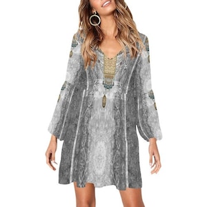 May include: A gray and white long-sleeved dress with a V-neck and a bohemian print. The dress has a flowing silhouette and bell sleeves.