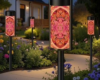 May include: Outdoor pathway lights with a black frame and a colorful, patterned design. The lights are installed along a garden path, surrounded by flowers and greenery. The lights illuminate the path at dusk.