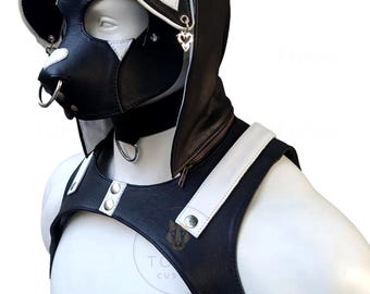May include: A black and white faux leather puppy hood with floppy ears, heart-shaped accents, and a metal nose ring, paired with a matching black and white chest harness featuring silver-toned hardware and snap button closures.