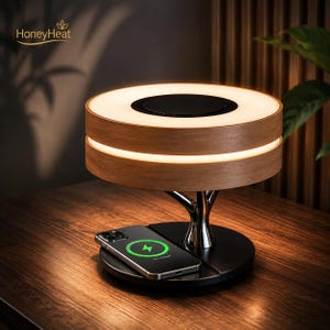 Può includere: Una lampada circolare con finitura in legno chiaro e un anello luminoso, sostenuta da un supporto metallico a forma di albero su una base nera. Uno smartphone è posizionato sulla base, mostrando un'icona di ricarica verde con il testo HoneyHeat.
