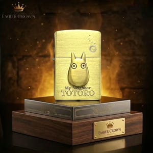 Puede incluir: Un encendedor dorado con el personaje Totoro de "Mi Vecino Totoro". El encendedor tiene un acabado texturizado y un dise&ntilde;o de sol. El encendedor se exhibe en una caja de madera con el logotipo "Ember Crown".