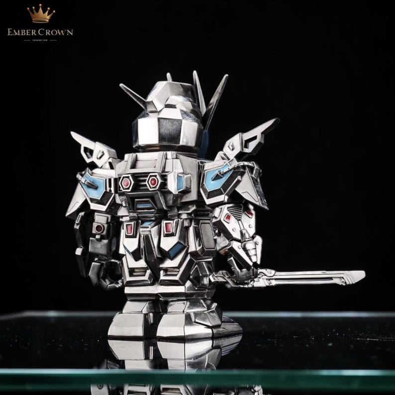 May include: A silver-colored robot figurine with a sword. The robot has a detailed design with blue and red accents. The Ember Crown logo is visible in the upper left corner.