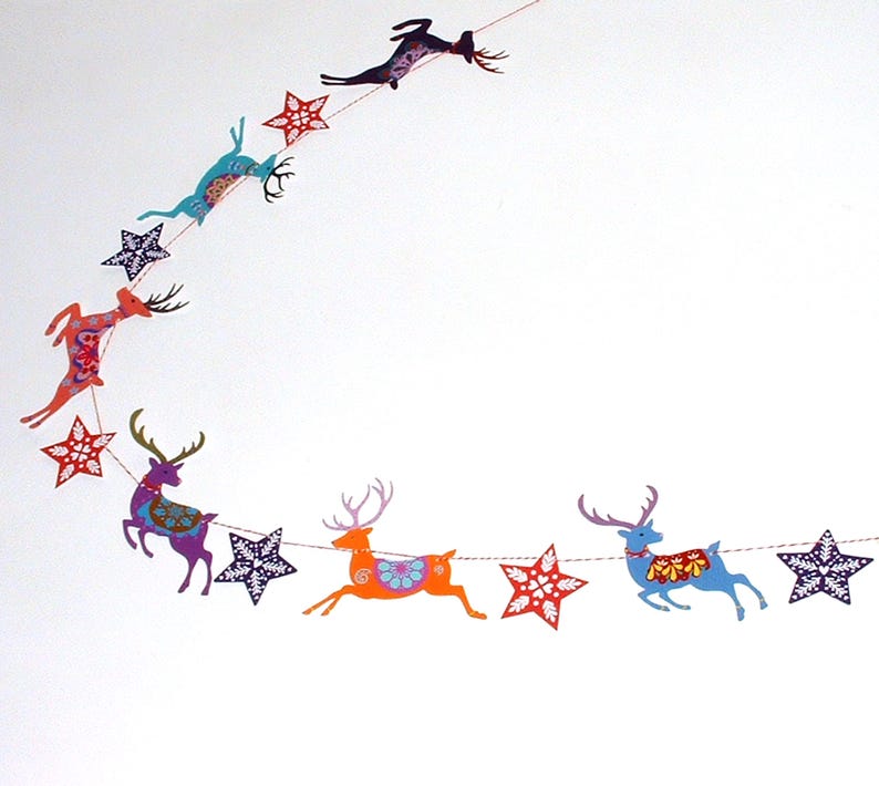 May include: A decorative garland featuring a series of colorful reindeer and star-shaped cutouts strung together on a thin cord. The reindeer are depicted in various poses and colors, including orange, purple, blue, and teal, with intricate patterns.