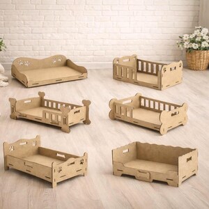 May include: Six unfinished wooden pet beds in different designs. Some have headboards and footboards, others are open. The beds feature paw prints and bone-shaped cutouts, indicating a pet-friendly theme. The beds are made of wood.