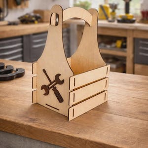 Può includere: Un portautensili in legno chiaro con manico e un design intagliato di una chiave inglese e un cacciavite. Il portautensili ha tre doghe orizzontali ed è appoggiato su una superficie di legno.