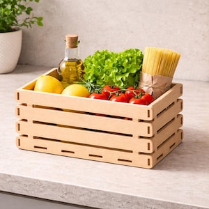 Puede incluir: Una caja de madera llena de ingredientes frescos para cocinar. La caja contiene limones, tomates, lechuga, una botella de aceite de oliva y un manojo de espaguetis. La caja está sobre una encimera.