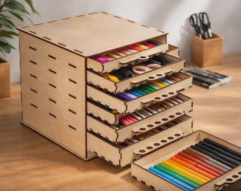 May include: A wooden desk organizer with multiple drawers, filled with colorful art supplies. The organizer is made of light-colored wood and has a rectangular shape. The drawers are open, revealing pens, pencils, and scissors.